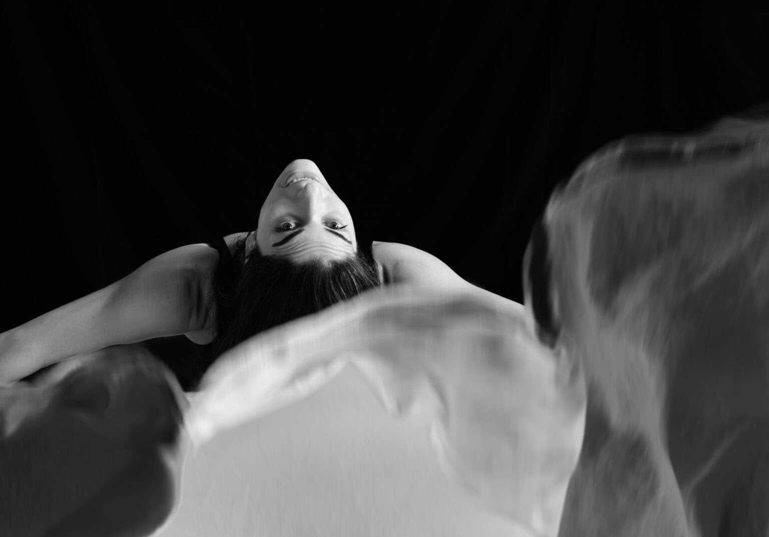 Portrait artistique créatif en noir et blanc. Photographié par une femme. Danseuse de flamenco faisant un mouvement vers l'arrière avec les bras ouvert lançant un grand châle blanc